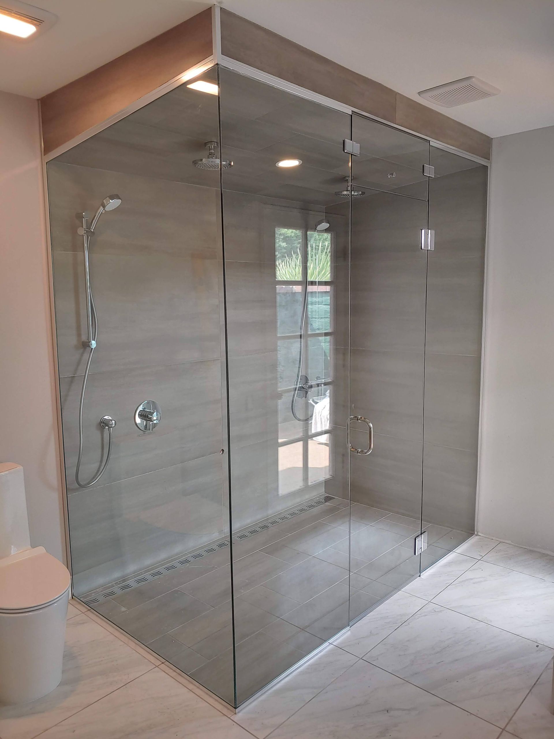 A bathroom with a walk in shower and a toilet.