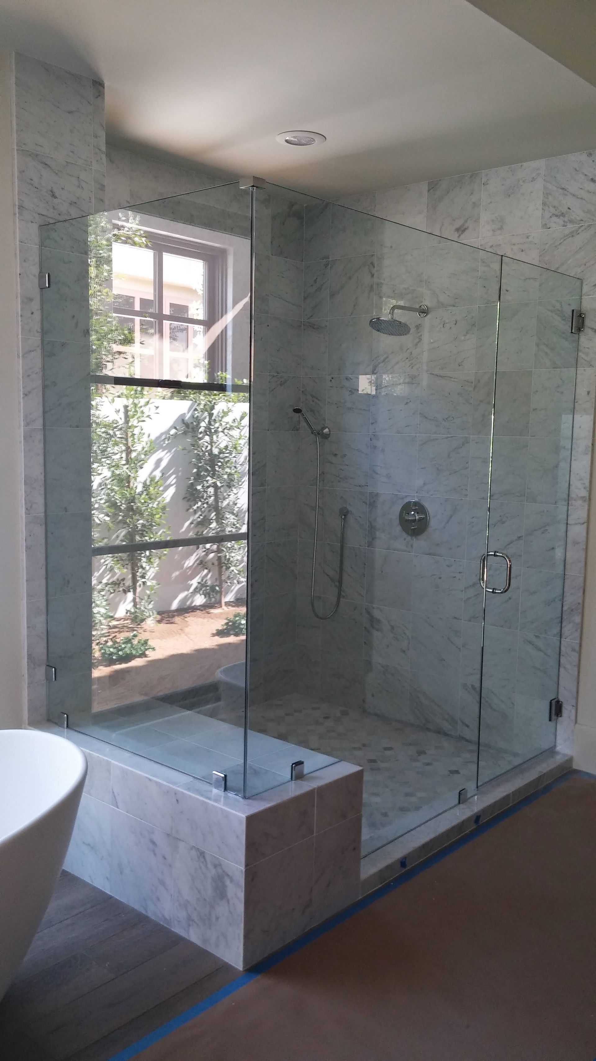 A bathroom with a walk in shower and a bathtub.