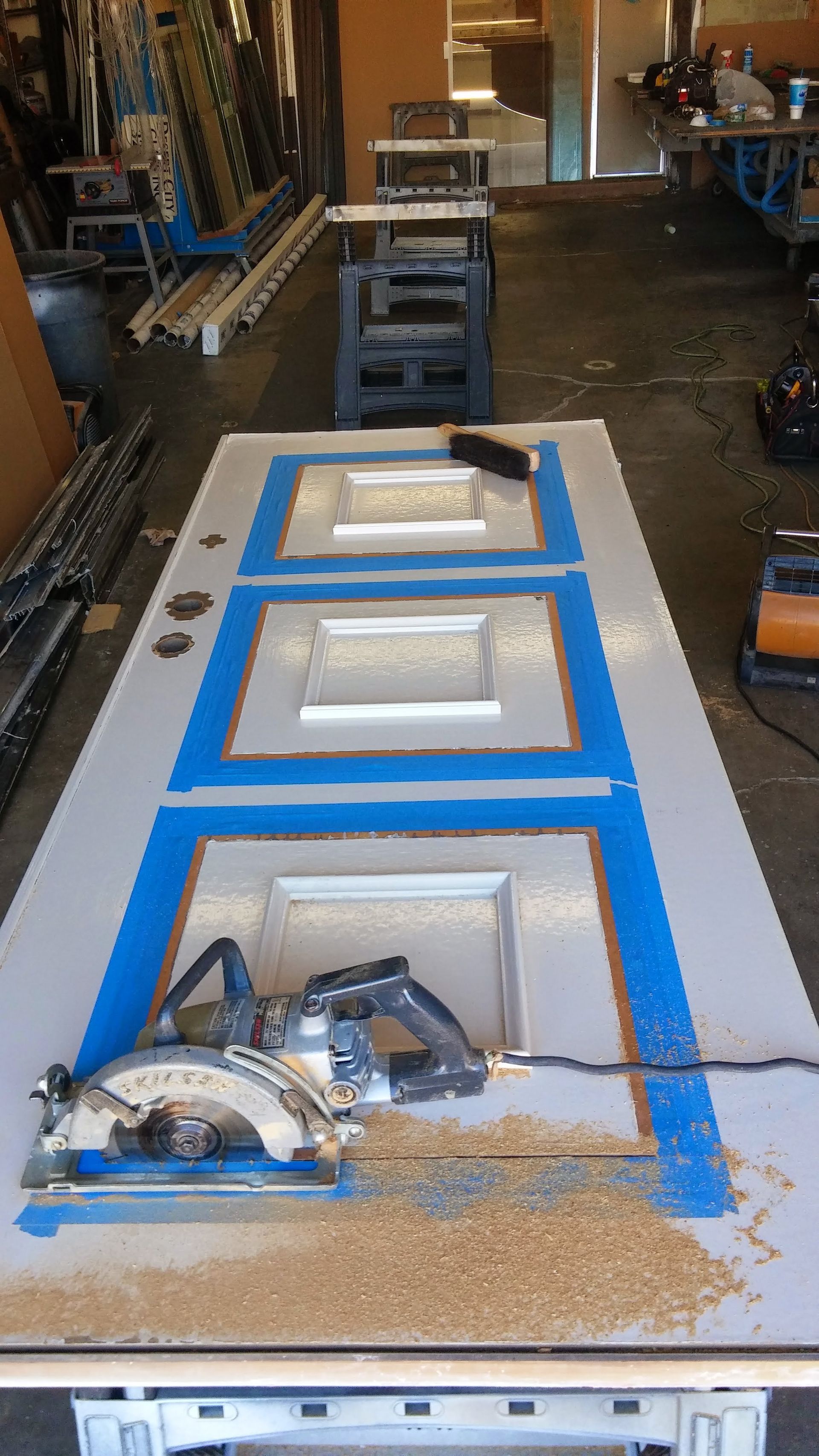 A circular saw is cutting a door in a workshop.