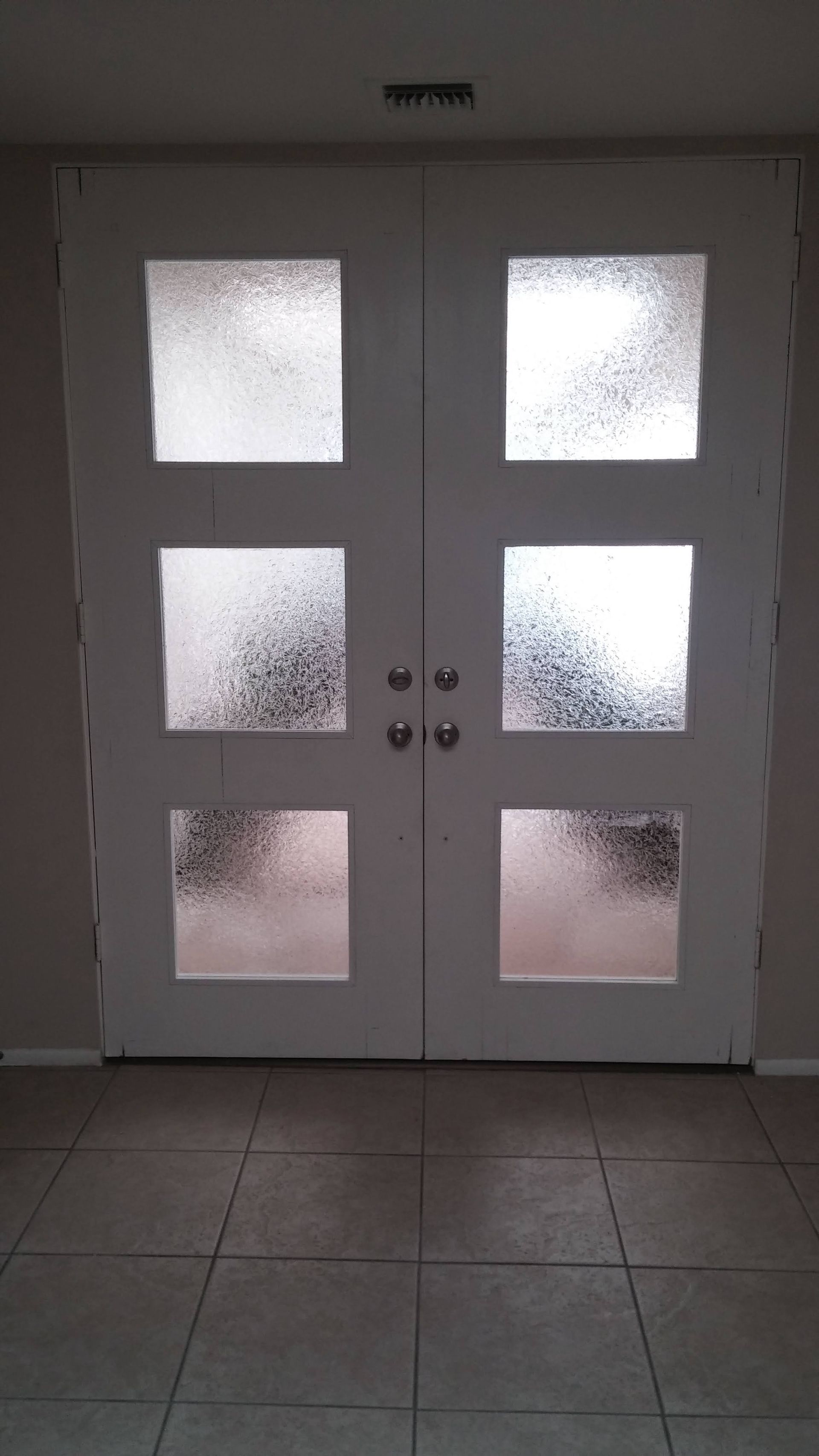 A white door with frosted glass in a hallway.