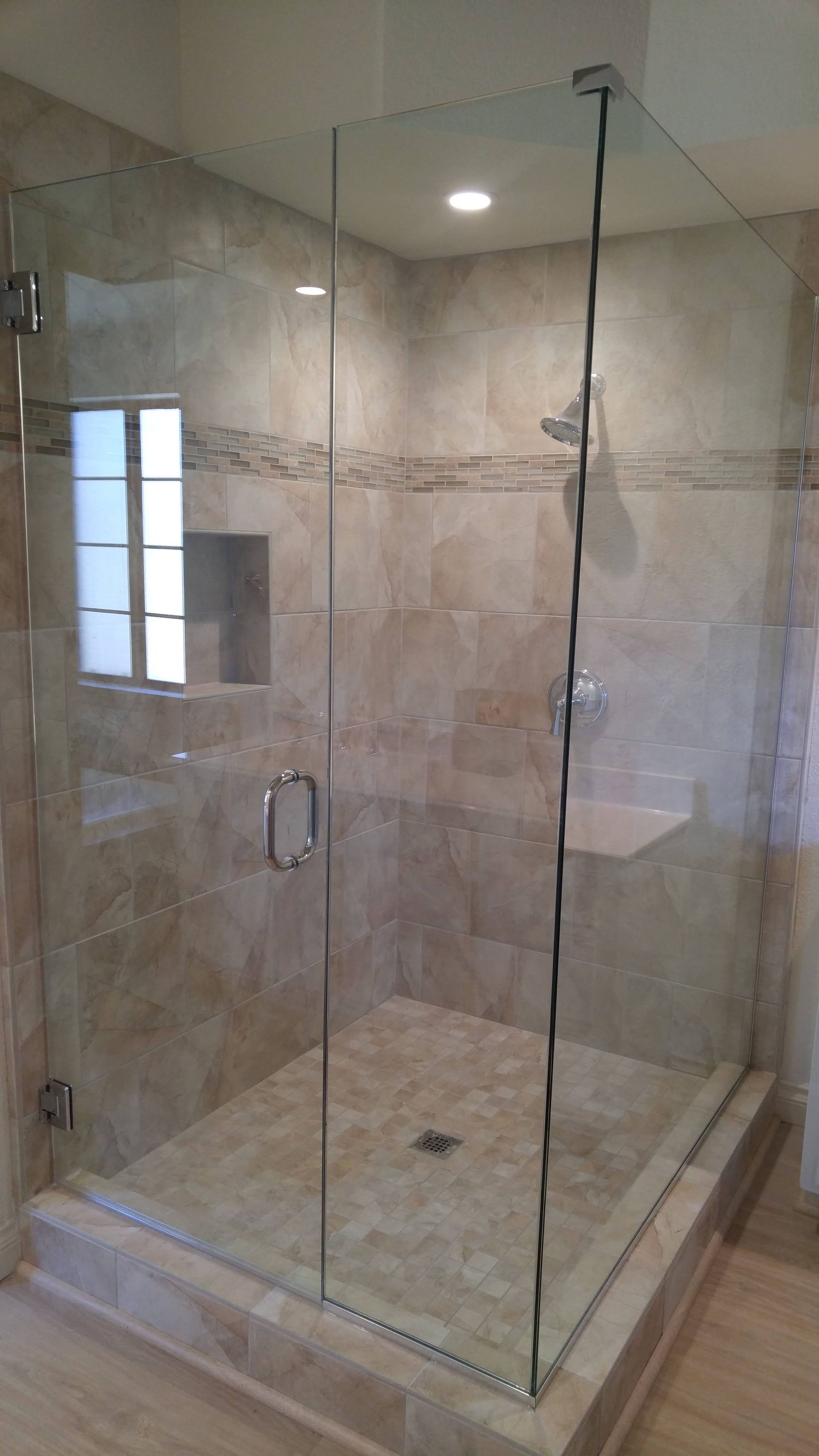 A bathroom with a walk in shower with a glass door.