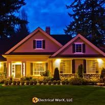 A large house with a lot of windows is lit up at night.