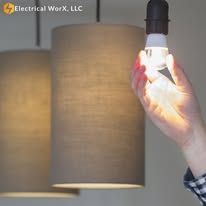 A person is holding a light bulb in their hand.