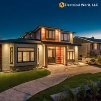 A large house with a walkway leading to it is lit up at night.