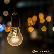 A light bulb is hanging from a ceiling in a dark room.