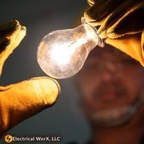 A man is holding a light bulb in his hand.