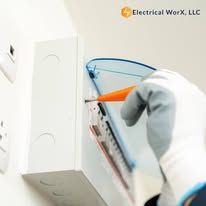 A person is installing an electrical box on a wall.