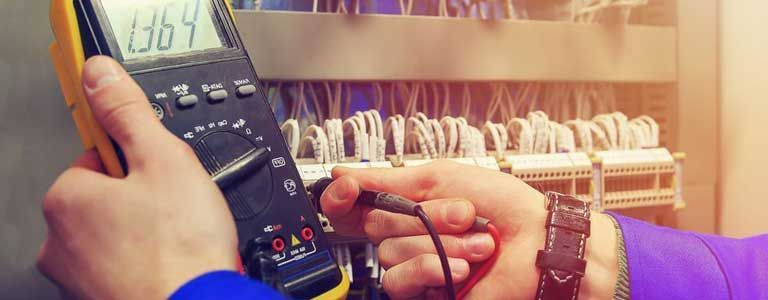 A person is holding a multimeter in their hands.