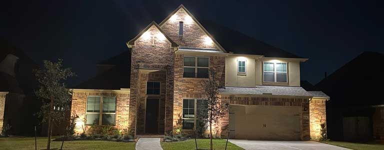 A large brick house is lit up at night.