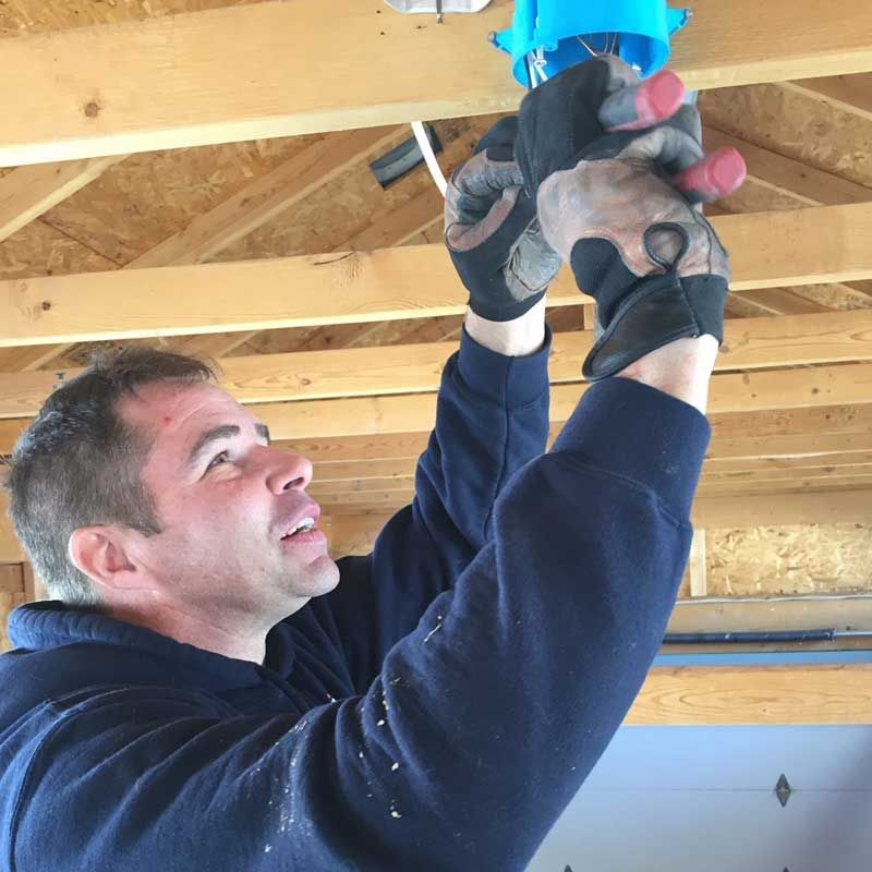 A man wearing gloves is working on a ceiling