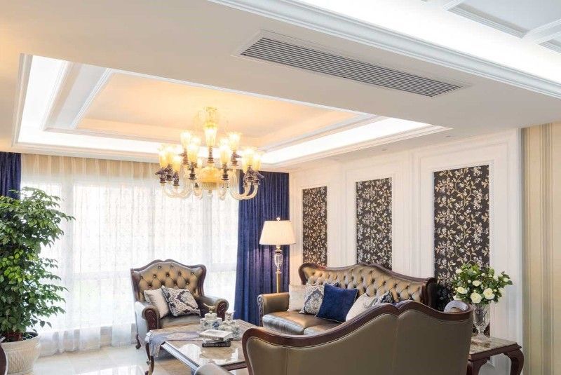 A living room with a couch , chair , table and chandelier.