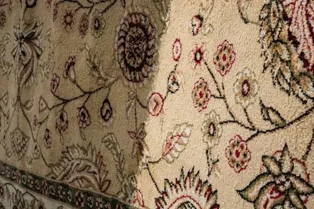 Beige floral-patterned fabric with black and red intricate designs and folds
