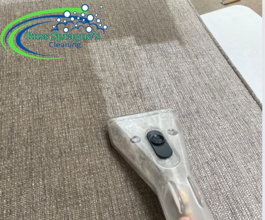 Carpet cleaning nozzle vacuuming a beige textured rug indoors