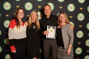 A group of people are posing for a picture with a man holding a certificate.