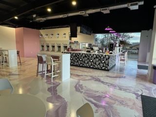 A restaurant with a marble floor and tables and chairs.