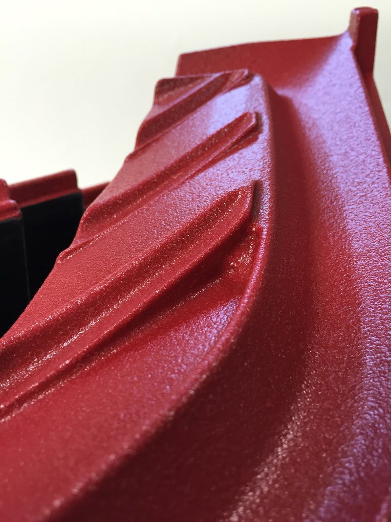 A close up of a red object on a white surface.