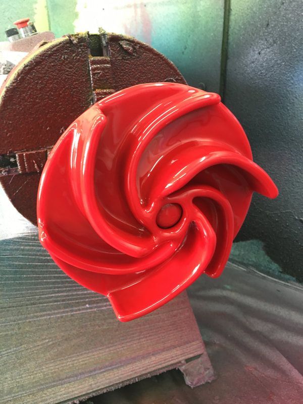 A red swirl shaped object is sitting on a table