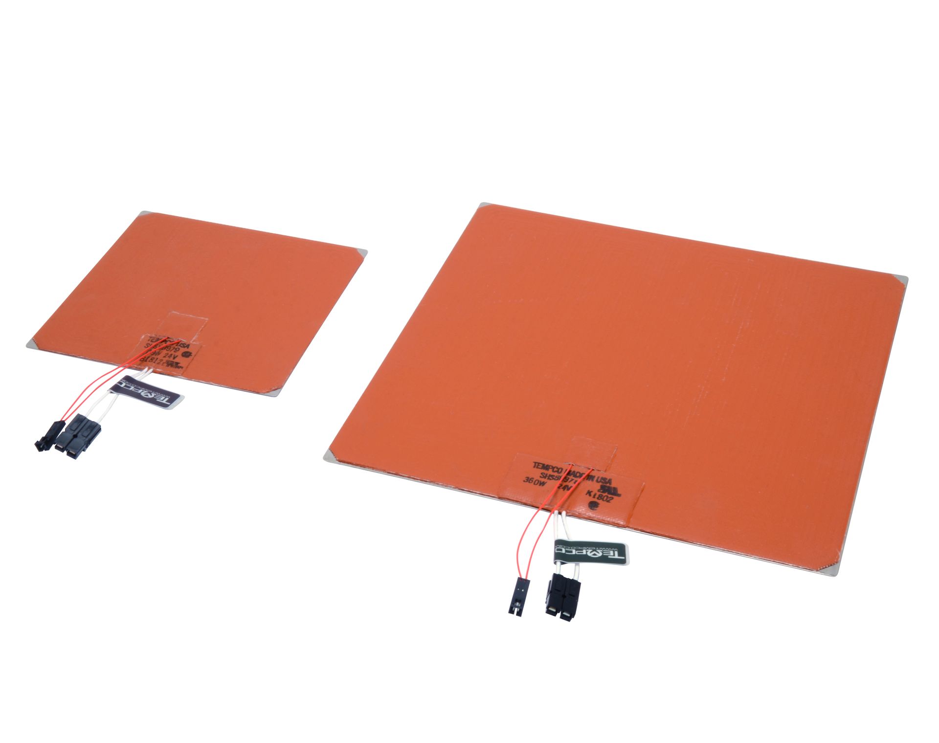 Two orange heated mats with attached power cords on a white background
