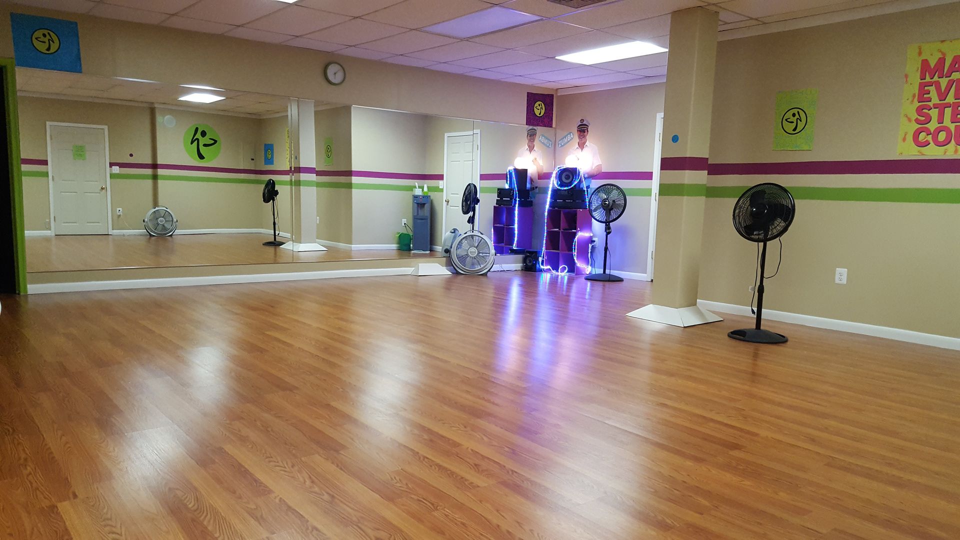 An empty dance studio with a large mirror on the wall.