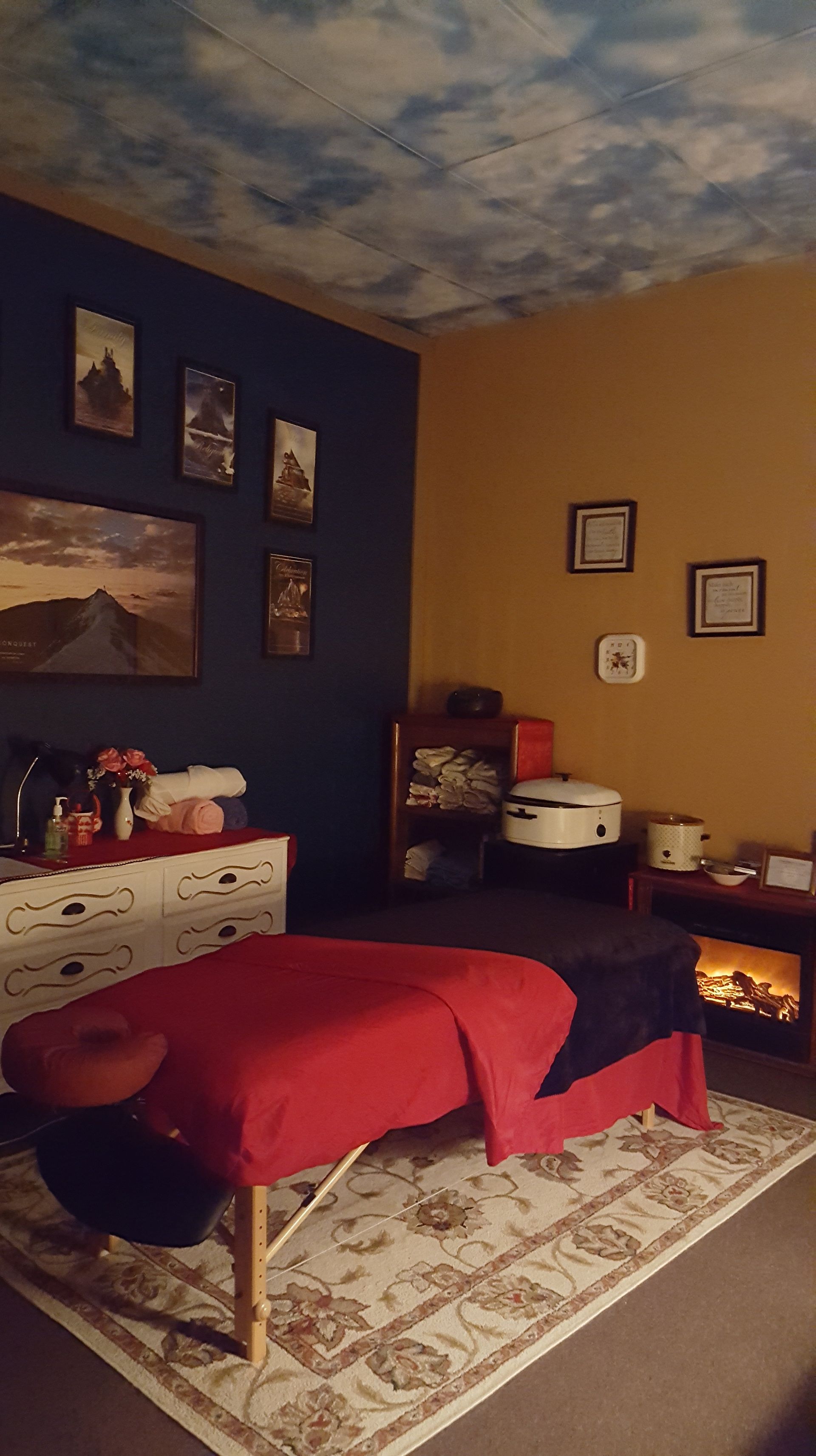 A massage table is sitting in a room with a fireplace.