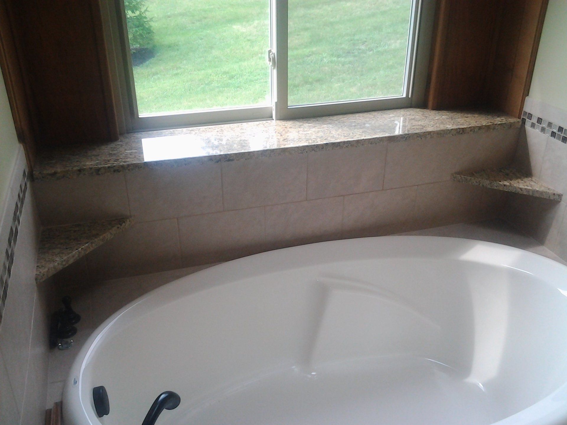 A bathtub in a bathroom next to a window.