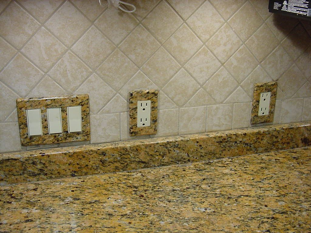 A kitchen counter with three electrical outlets on it