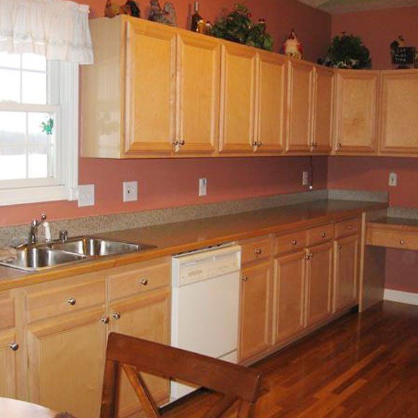 A kitchen with wooden cabinets and a white dishwasher