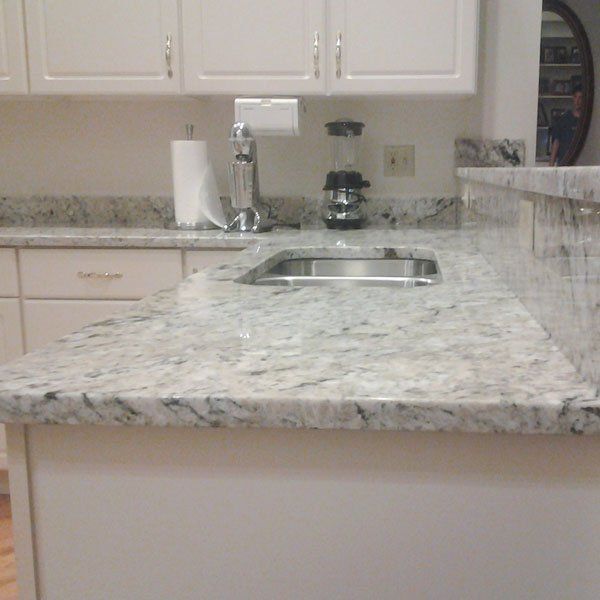 A kitchen with a granite counter top and a sink.