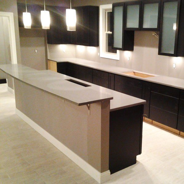 A kitchen with black cabinets and white counter tops