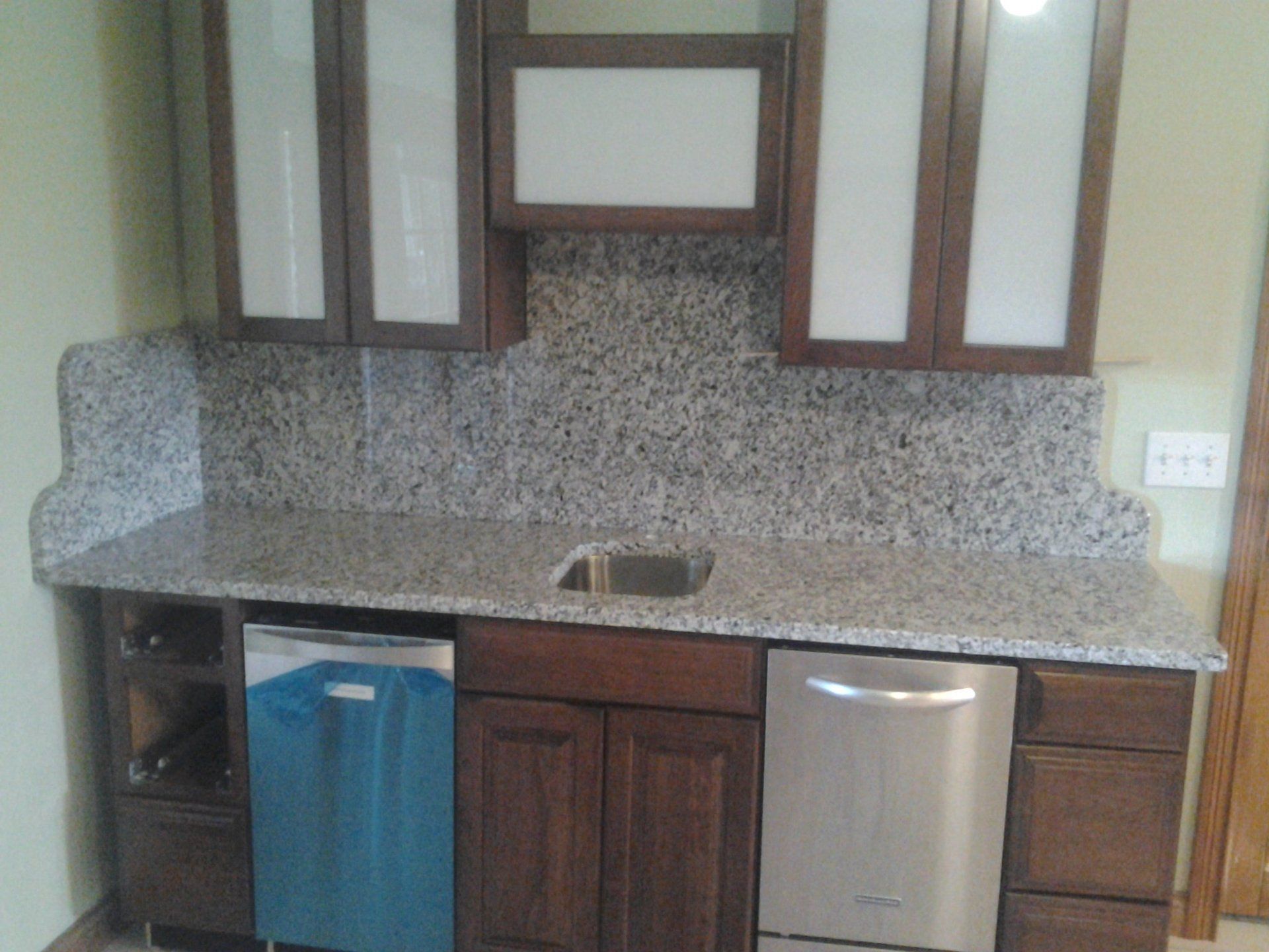 A kitchen with granite counter tops and stainless steel appliances