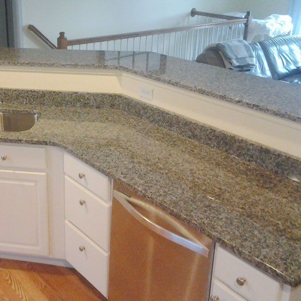 A kitchen with granite counter tops and white cabinets