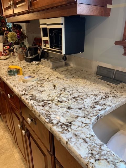 A kitchen with granite counter tops and stainless steel sink.