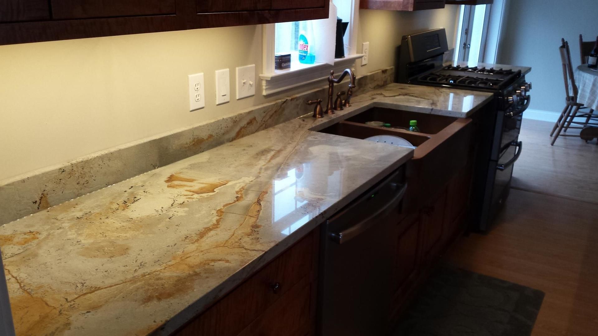 A kitchen with a sink , stove , and dishwasher.