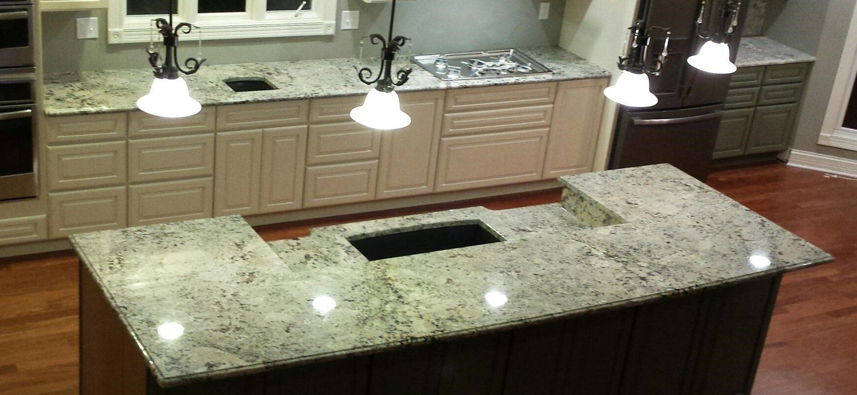 A kitchen with a large island and granite counter tops