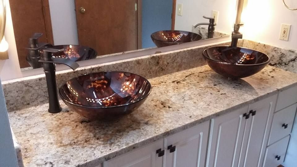 A bathroom counter with two sinks and a mirror
