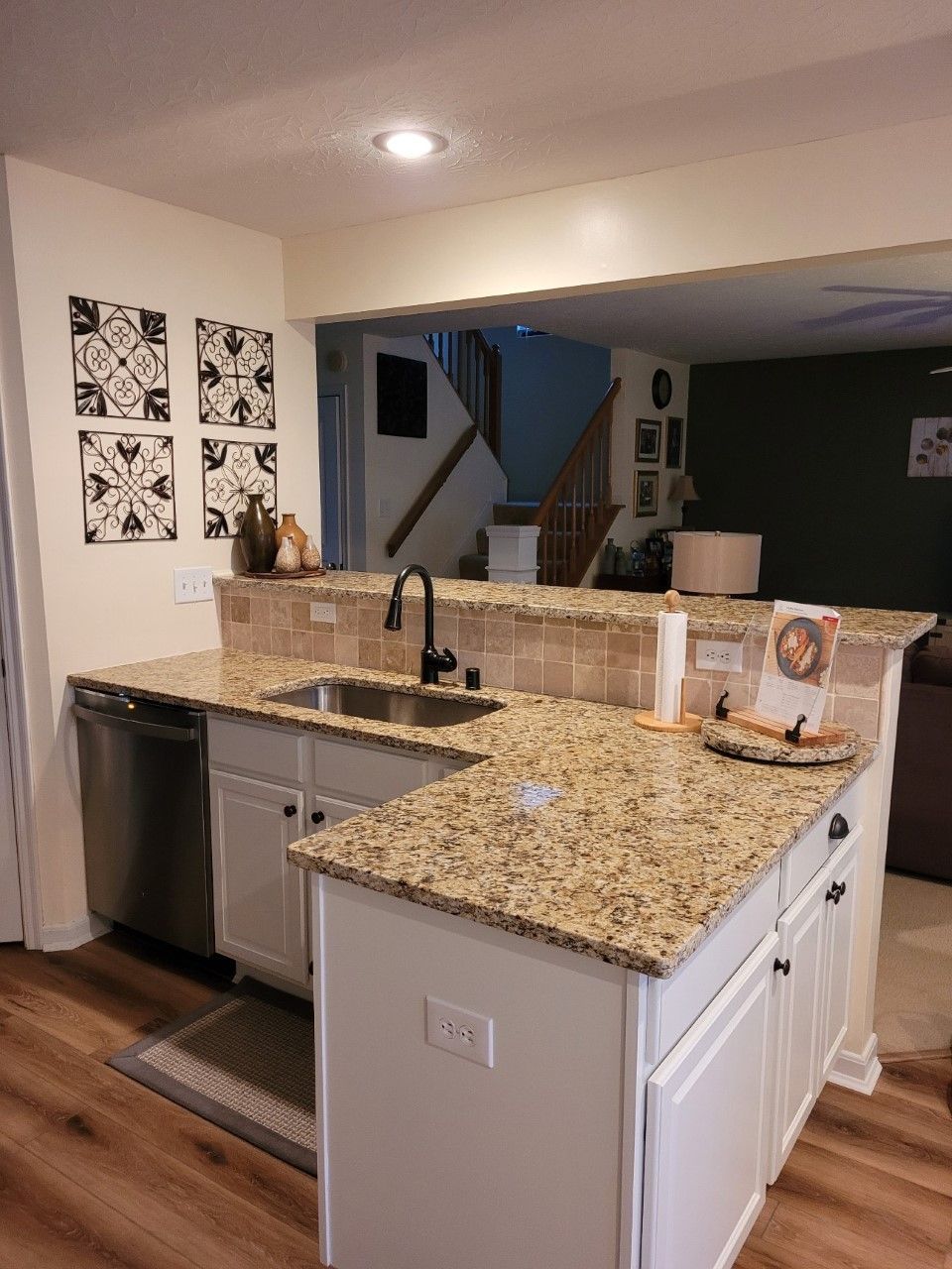 A kitchen with granite counter tops and white cabinets