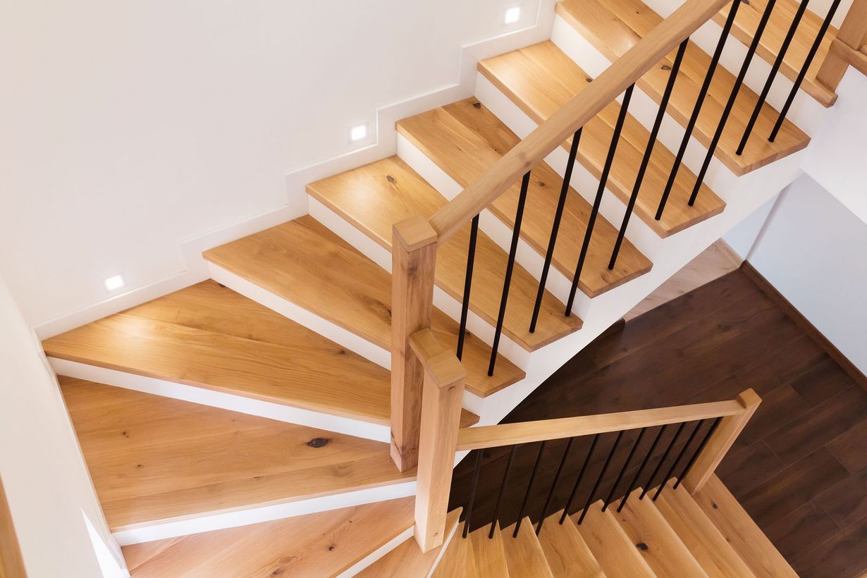 Wooden stairway and ramp to a raised building entrance beside a gray-sided house