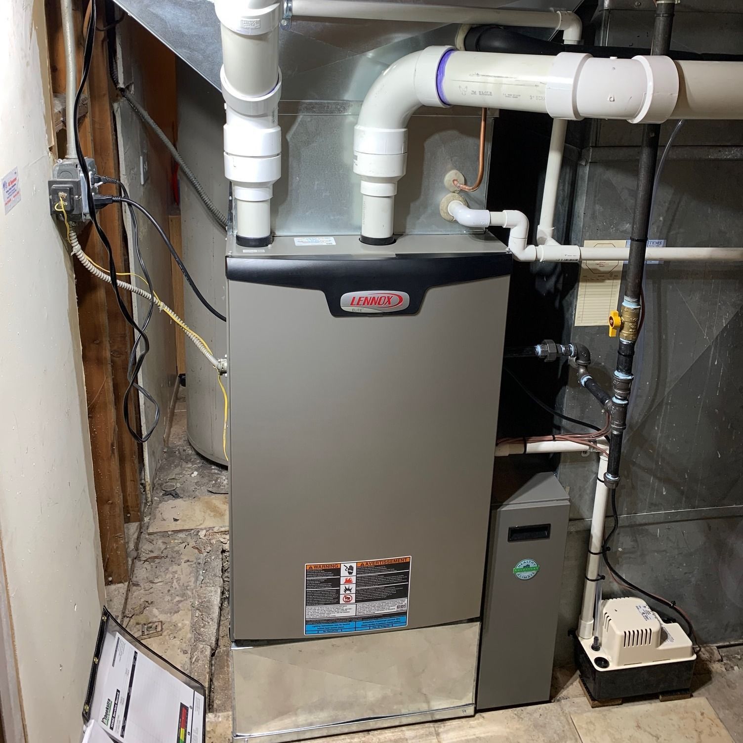 Lennox furnace in a basement setting with ductwork and a water heater.