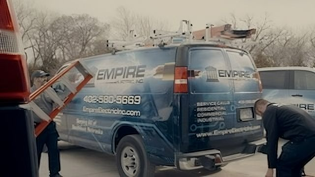 A man in a suit is standing next to a blue van.