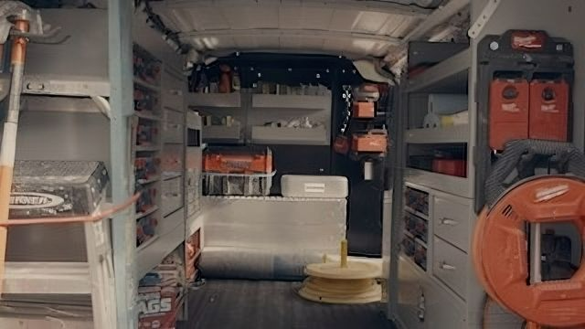 The inside of a van filled with tools and shelves.