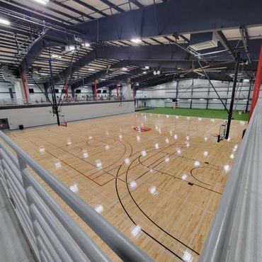 A large indoor basketball court with a wooden floor