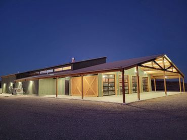 A large building with a lot of windows and doors is lit up at night.