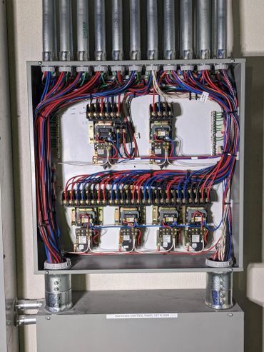 A close up of a electrical box with a lot of wires coming out of it.