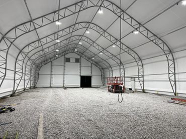 A large warehouse with a red lift inside of it.