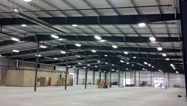 A large warehouse with a lot of lights on the ceiling