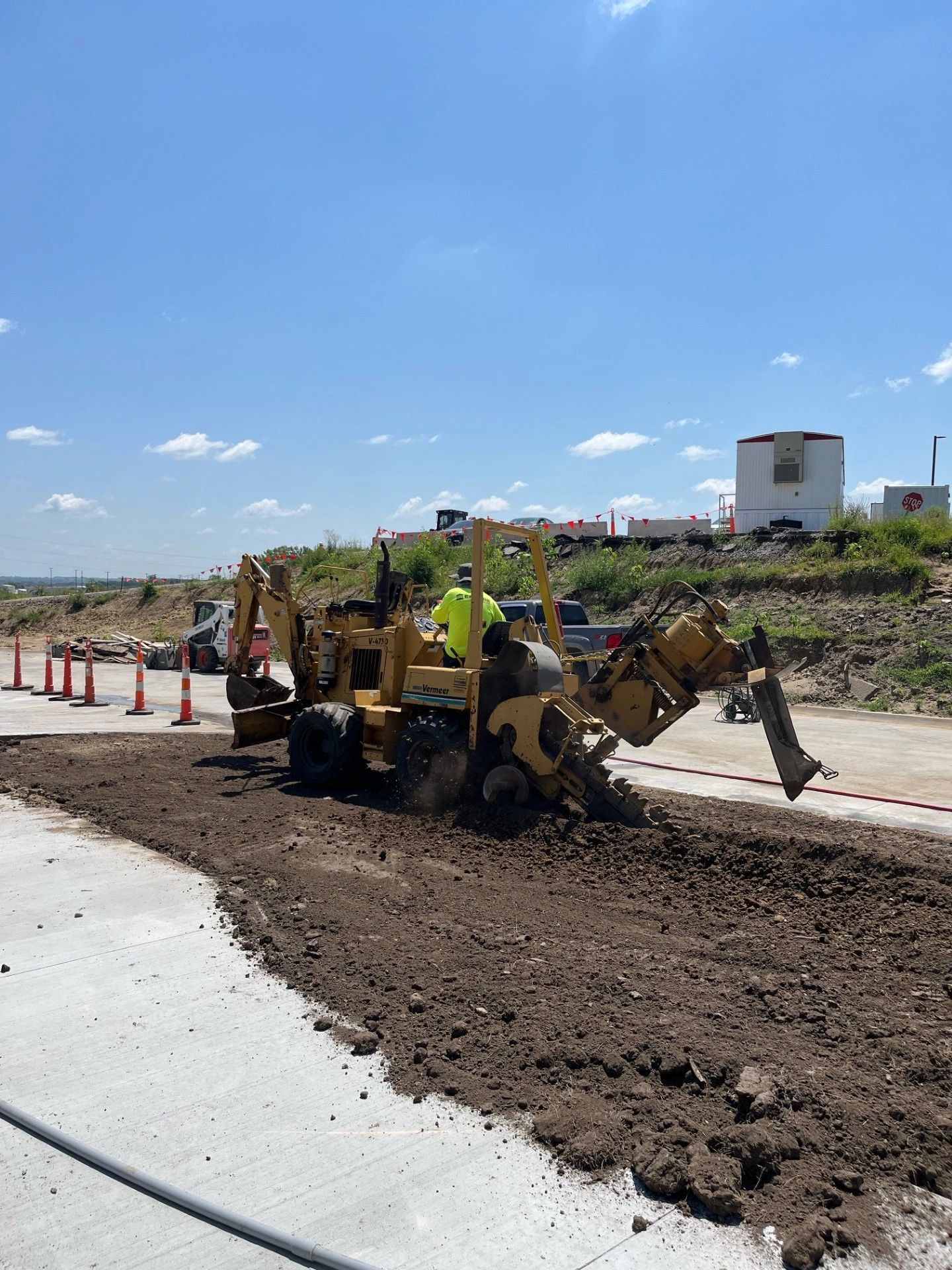 A man is driving a bulldozer on a dirt road.