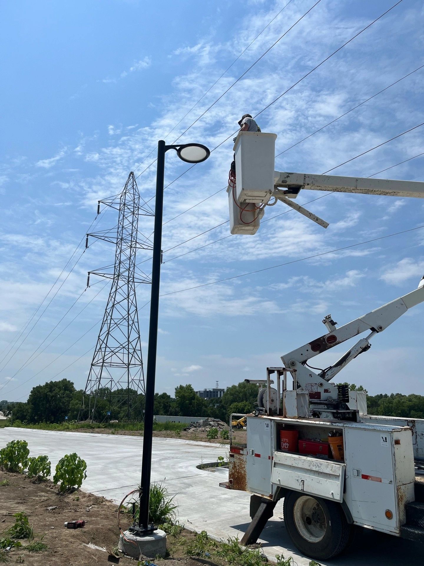 A man is working on a street light with a crane.