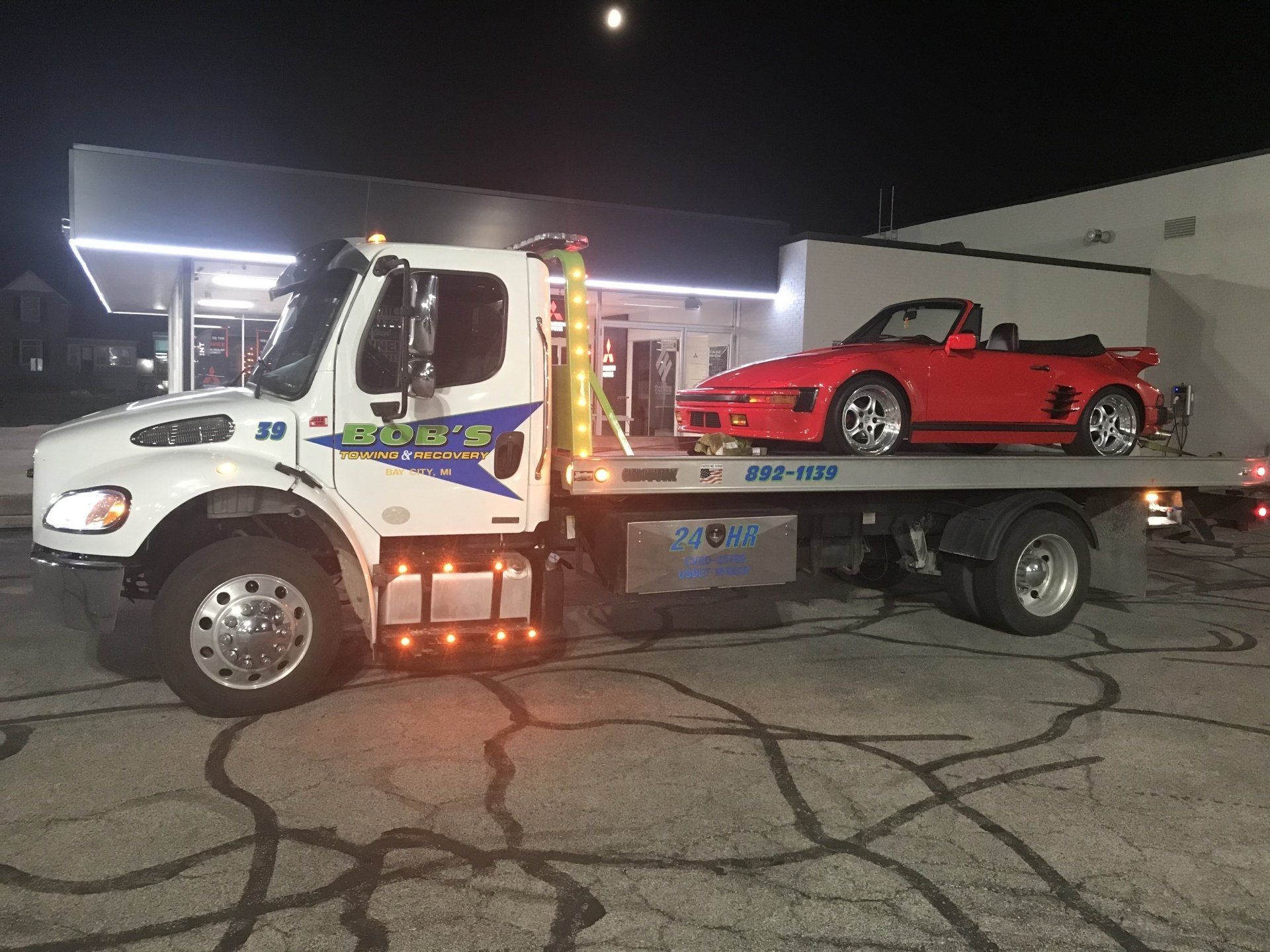 Red convertible car towing