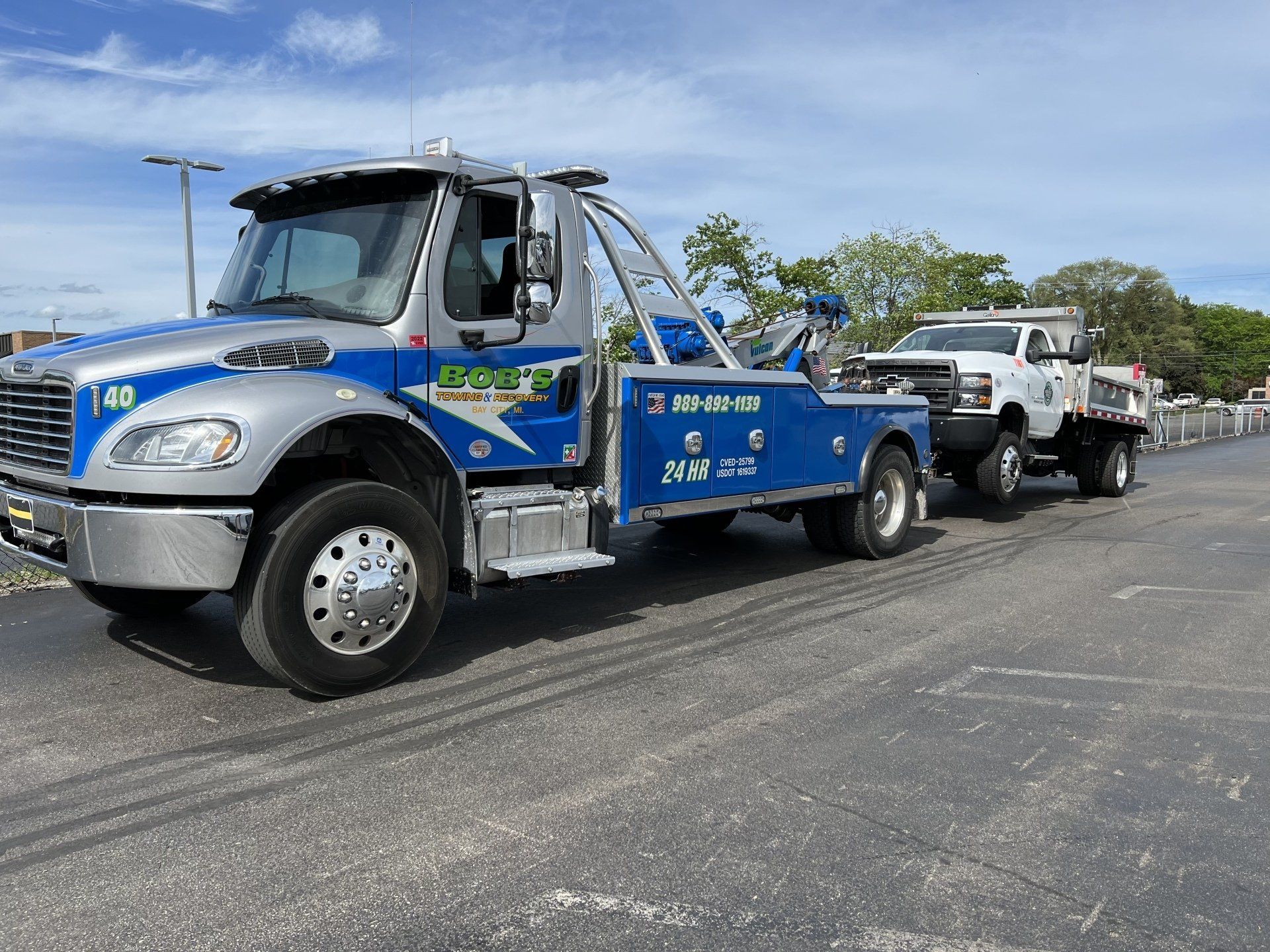 Blue tow truck with white small truck