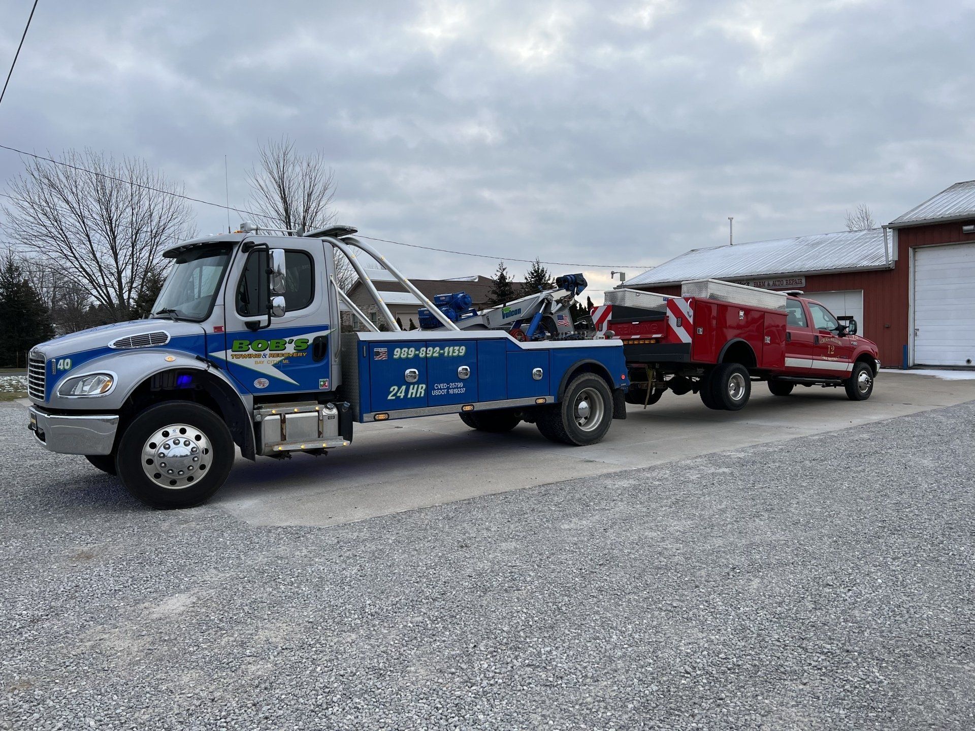 Blue tow truck with red truck